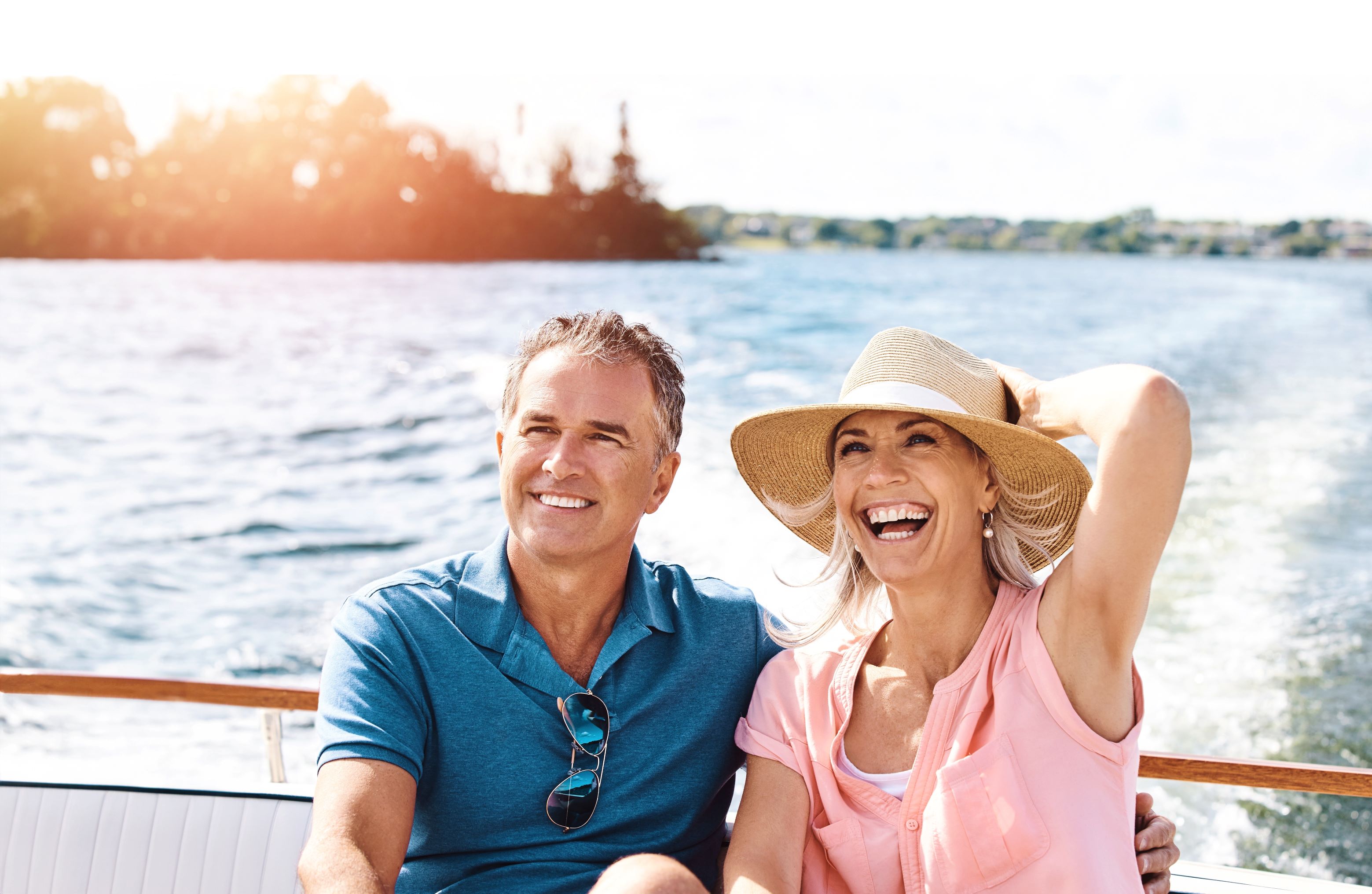 A smiling retired couple laughing together on a boat on the water, illustrating the article on U.S. retirement account distributions